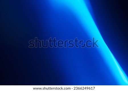 Blue neon light. A smooth streak of light from the side of the frame