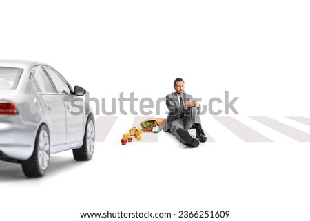 Businessman hit by a car sitting at pedestrian crossing isolated on white backgroundd