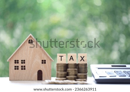 Tax concept,Model house with stack of coins money and tax word on green background,Business investment and Property tax concept Royalty-Free Stock Photo #2366263911