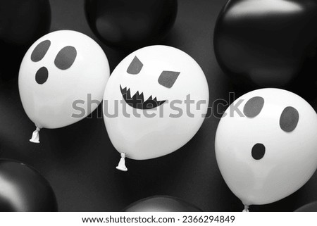 Different funny Halloween balloons on black background