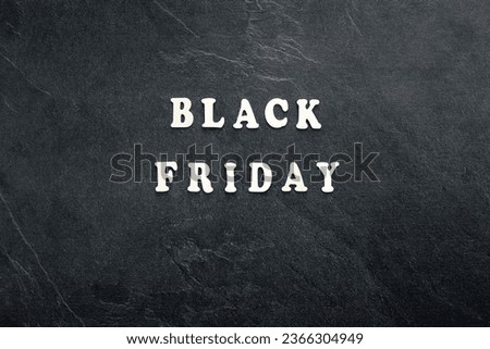 Wooden text Black friday on black textured background, top view.