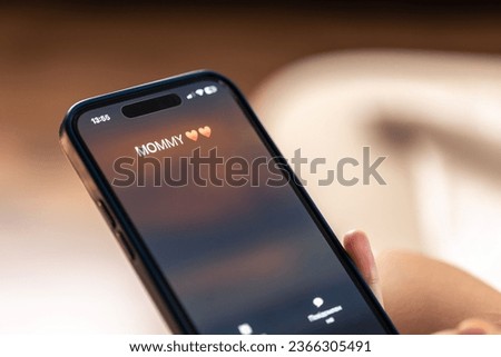Smartphone in child hands with Incoming Mommy call on a screen. Royalty-Free Stock Photo #2366305491
