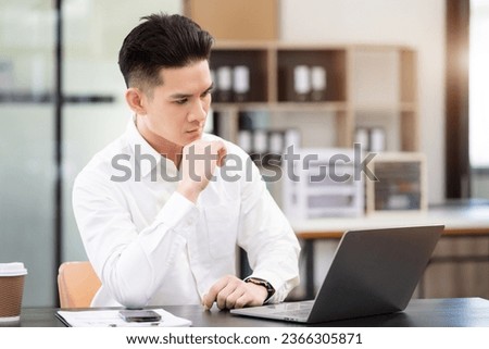 Businessman using laptop computer in office. Happy man, entrepreneur, small business owner working online.