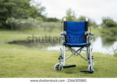 Patient wheelchair, close-up view of empty wheelchair with sidewalk handicap sign
