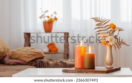 burning candles with autumn decor on white table at home Royalty-Free Stock Photo #2366307493