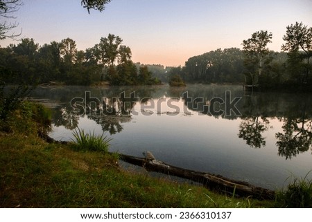 In Donau-Auen of Vienna's Lobau region, the early morning light illuminates Dechantlacke, a natural lake within the Danube National Park, offering a peaceful reflection of the autumn landscape.