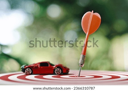 close up dart arrow hitting on target center, toy car on dartboard, planning and manage to success transport business, transportation insurance technology, economic crisis risk and problem concept
