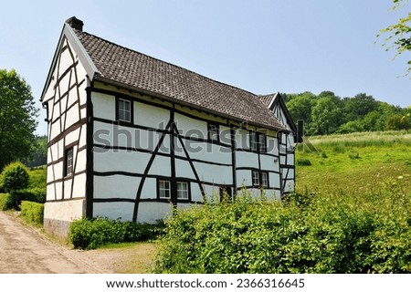 characteristic half-timbered house on a country road in the Limburg hill country Royalty-Free Stock Photo #2366316645