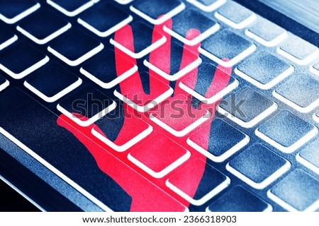 Internet danger background. Safe internet surfing. Red hand isolated on computer keyboard. Stop hackers. Security alety. Rick of hacker attack. Do not get robber online.