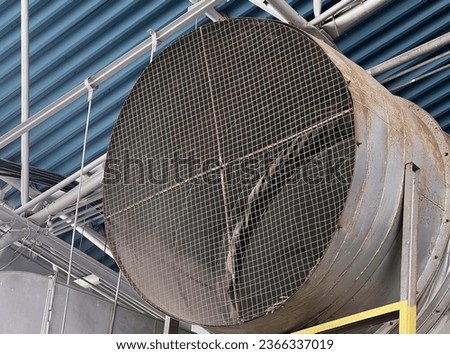 a photography of a large metal tube with a metal mesh covering it.