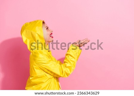 Side profile photo of funny hipster girl enjoy trendy jacket yellow design catching two arms raindrops isolated on pink color background