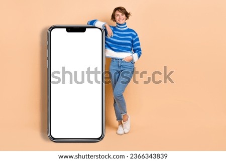 Full size photo of pretty positive girl demonstrate huge empty space telephone display isolated on beige color background