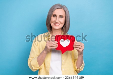 Photo of adorable pretty lady wear yellow shirt holding feedback heart card isolated blue color background
