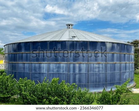 Weathered, vertical, above ground water storage tank.
