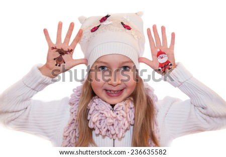 Happy girl demonstrating painted Christmas symbols on her hands. Santa Claus and reindeer
