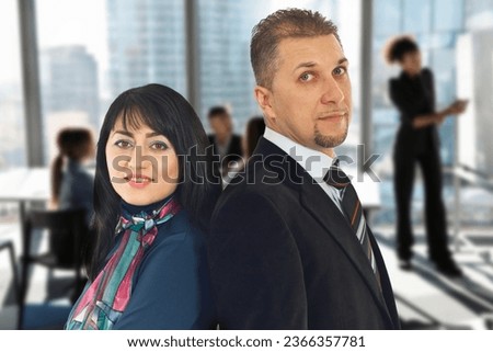 Portrait of two business people standing back to back isolated on white background