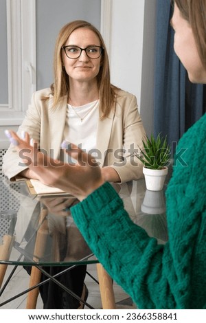 Psychological counseling. Close-up of a psychologist with a patient sitting at a table in the office. Concept of psychological health, psychotherapy. Vertical photo