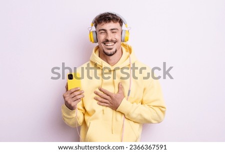 young handsome man laughing out loud at some hilarious joke. music concept