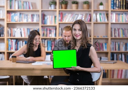 Businesswoman holding tablet green screen coma key for use in entering presentation text and advertisement at meeting room office. businessperson showing green screen monitor.