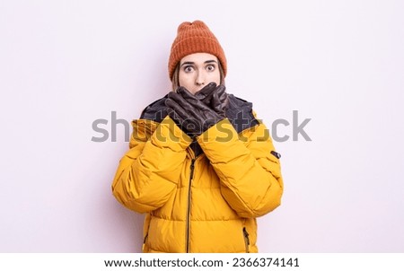 young pretty woman covering mouth with hands with a shocked. winter concept