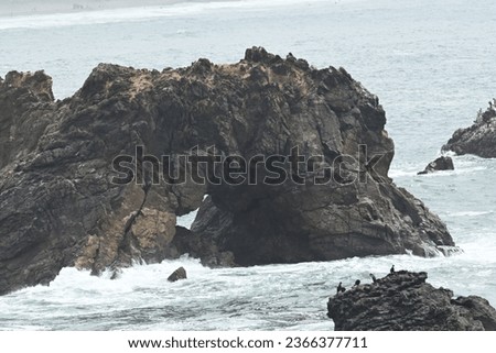 natural ocean rock arch with waves crashing against it