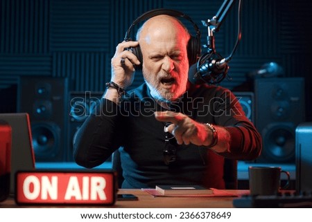 Confident radio DJ talking into the mic and gesturing, music and entertainment concept