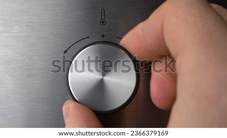 Adjusting Electric Oven Temperature by Turning the Oven Switch Close Up Royalty-Free Stock Photo #2366379169