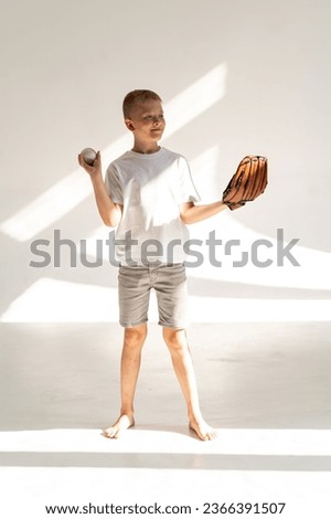Boy playing with baseball and glove on white background
