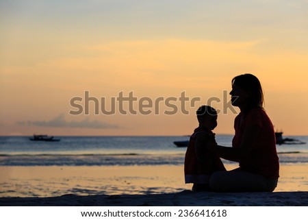 mother and little daughter on sunset tropical beach