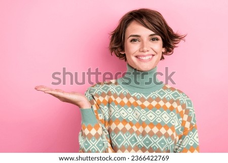 Portrait of cheerful pretty person beaming smile arm palm hold demonstrate empty space isolated on pink color background