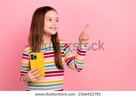 Photo of funny cute small girl point finger empty space new message advertising promoting eshopping page isolated on pink color background
