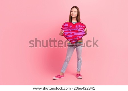 Full body photo picture small young age person girl brown hair hold her favorite candies surprise heart isolated on pink color background