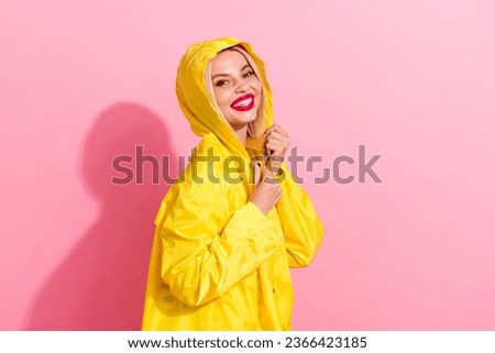 Side picture of nice red lips cute girlfriend hiding her head hood yellow waterproof warm jacket isolated on pastel pink color background