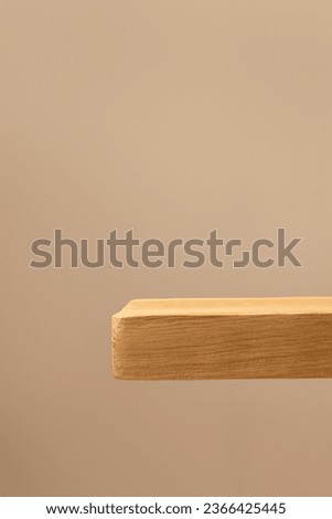 Wooden shelf against a beige wall. Background