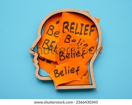 Bias concept. The outline of head is filled with pieces of paper with the inscription Belief. Royalty-Free Stock Photo #2366430345