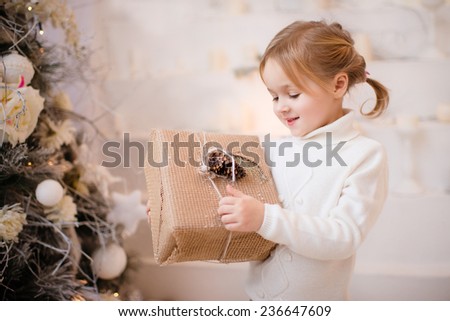 Portrait of little girl opening gift box isolated