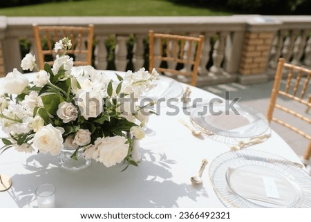 White roses adorn table at elegant wedding reception. Royalty-Free Stock Photo #2366492321