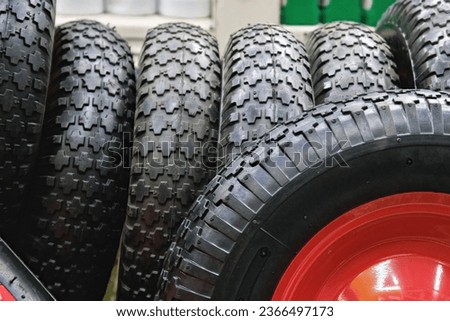 black rubber barrow wheels with grippy tread surface, closeup with selective focus
