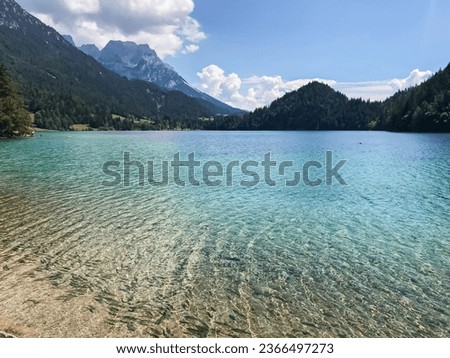 Huge mountain blue lake. Untouched wildlife of Europe. Majestic mountains covered with trees rise above the turquoise clean lake