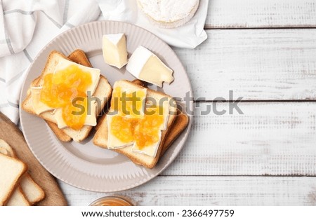 Tasty sandwiches with brie cheese and apricot jam on white wooden table, flat lay. Space for text Royalty-Free Stock Photo #2366497759
