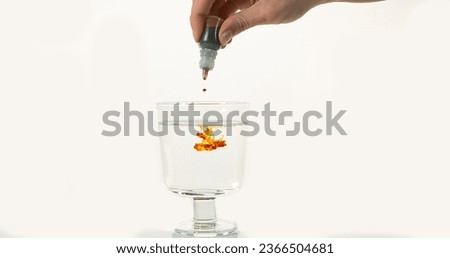 Medecine Falling into a Glass against White Background
