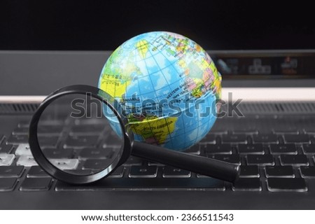 Laptop keyboard with world globe on top. The concept of searching for information data on the Internet.
