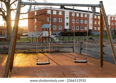 Two swings on a modern playground in Europe, Sweden. Typical playground in a residential area.  Royalty-Free Stock Photo #2366513935