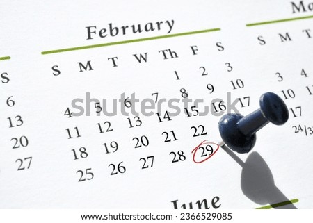A pushpin and red circle in ink marking Leap Year Day, February 29, on a calendar Royalty-Free Stock Photo #2366529085
