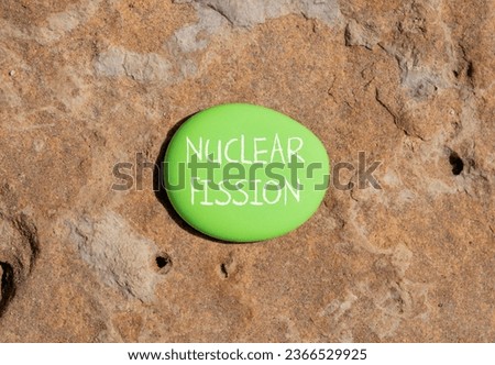 Nuclear fission symbol. Concept words Nuclear fission on beautiful big green stone. Beautiful stone wall background. Business science nuclear fission concept. Copy space. Royalty-Free Stock Photo #2366529925