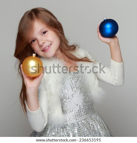 Portrait of happy girl looking at decorative toy ball on Christmas