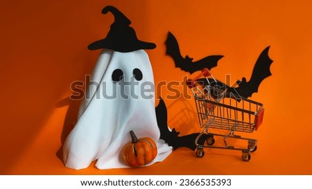 orange background for Halloween decoration. October 31, autumn holiday. a ghost in a hat, a pumpkin and flying mice.