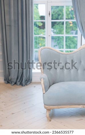 luxury vintage style blue sofa in royal living room. couch near large windows. baroque interior, daylight