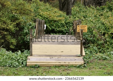 A wooden footbridge with a sign that says no motorized vehicles.