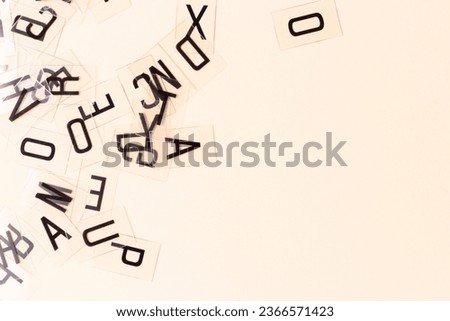 Transparent plastic cards with letters scattered on a beige background. Place for your design.